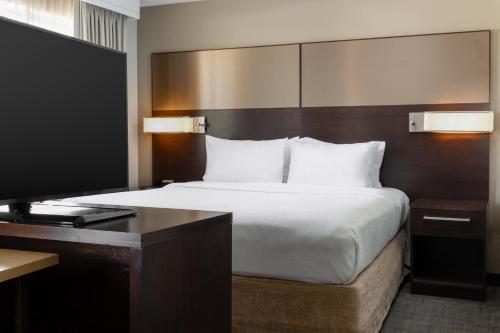 a bedroom with a bed and a desk with a television at Residence Inn by Marriott Youngstown Warren/Niles in Niles