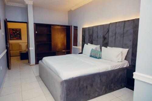 a bedroom with a large bed with a wooden headboard at OVIC Hotel in Benin City