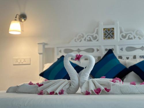 two swans made out of towels on a bed at Oceanic - Luxury Boutique Hotel in Palolem