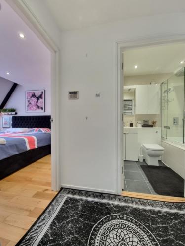 a bathroom with a shower and a bedroom with a bed at Deluxe Townhouse Zone 1 Brick Lane in London