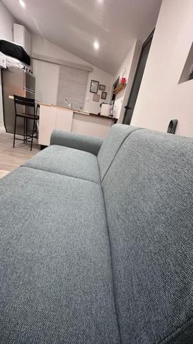 un canapé bleu dans un salon avec une table dans l'établissement LA VILLA DEKO - Studio indépendant, à Beuvry