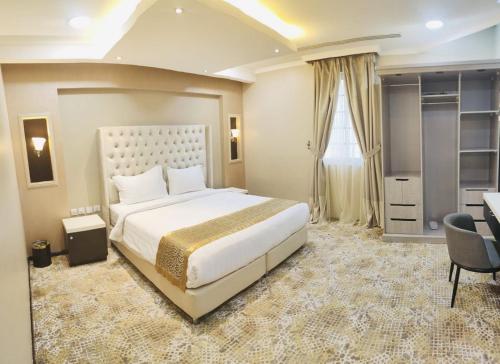 Schlafzimmer mit einem großen weißen Bett und einem Schreibtisch in der Unterkunft اصالة الشروق للشقق المخدومه in Khobar