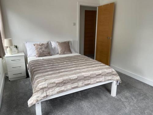 Un dormitorio con una cama con una manta. en Lovely Two Bedroom House in Central Kidlington, en Kidlington