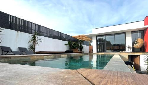 une piscine devant une maison dans l'établissement LA PALMERAIE, à Châtelaillon-Plage