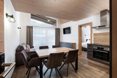 a kitchen and dining room with a wooden table and chairs at Appartement Christina in Saalbach Hinterglemm