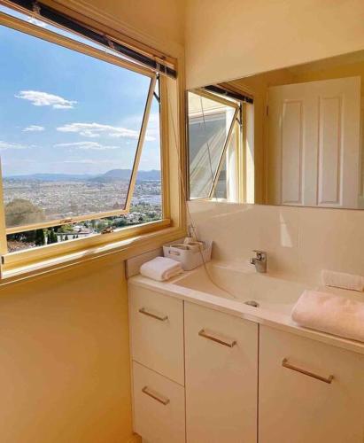 baño con lavabo y ventana grande en Millions View - Hobart, en Sandy Bay