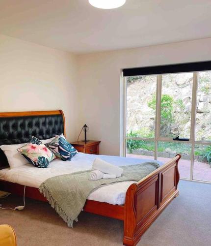 1 dormitorio con cama y ventana grande en Millions View - Hobart, en Sandy Bay
