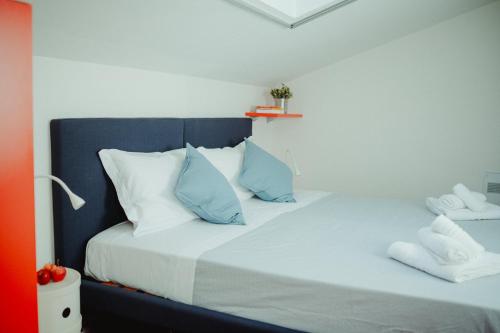 1 dormitorio con 1 cama con almohadas azules y blancas en Angolo a Corte, en Pietrasanta