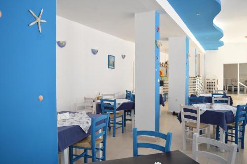 un restaurante con mesas y sillas azules y blancas en Hotel Sozopol en Sozopol