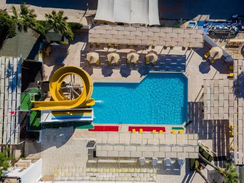 una vista aérea de una piscina con un tobogán amarillo en Petunya Beach Resort, en Ortakent