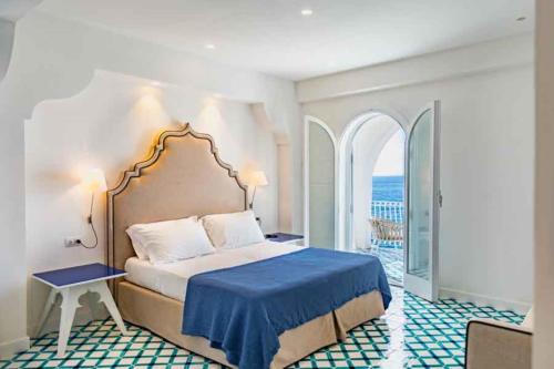 um quarto com uma cama com um cobertor azul em Amore Rentals - Villa dei Sogni em Massa Lubrense