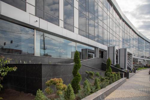 an external view of a building with trees in front of it at Expocore Hotel in Yerevan