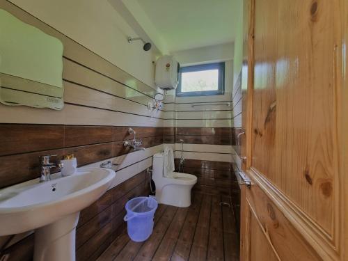 a bathroom with a sink and a toilet at Kihala Homestay in Manāli