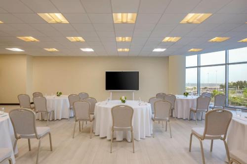 a conference room with tables and chairs and a flat screen tv at Le Meridien City Center Doha in Doha