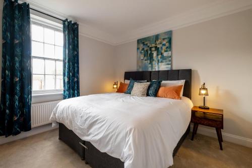 a bedroom with a large bed with blue curtains at Luxury home that sleeps up to 8 adults and 6 children - hot tub and parking for 4 cars in Bury Saint Edmunds