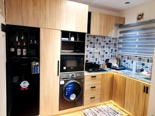 a kitchen with a washing machine in a kitchen at Bogotá by Homefront Encanto in Abuja