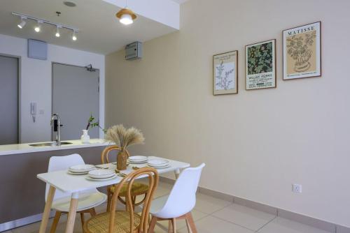 a kitchen and dining room with a white table and chairs at 10 min to My town family unit By Nexx Field in Kuala Lumpur