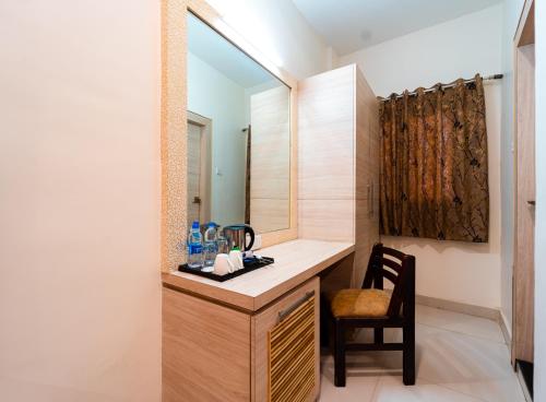 ein Badezimmer mit einem Waschtisch mit einem Stuhl und einem Spiegel in der Unterkunft Hotel Royal Palace in Sāgar