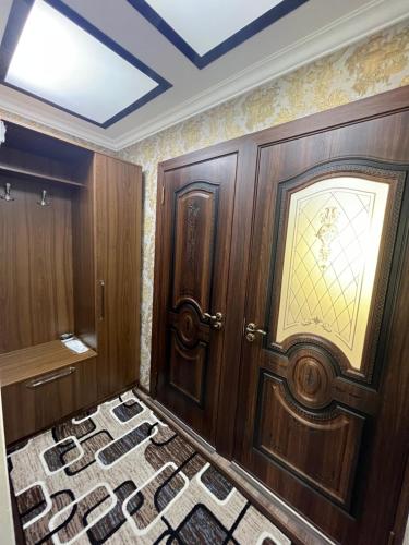 Habitación con puerta de madera y alfombra. en Welcome TJ Apartment en Khujand