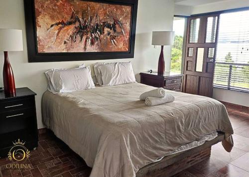 a bedroom with a bed and a painting on the wall at Cabaña tota paraiso con muelle in Cuítiva