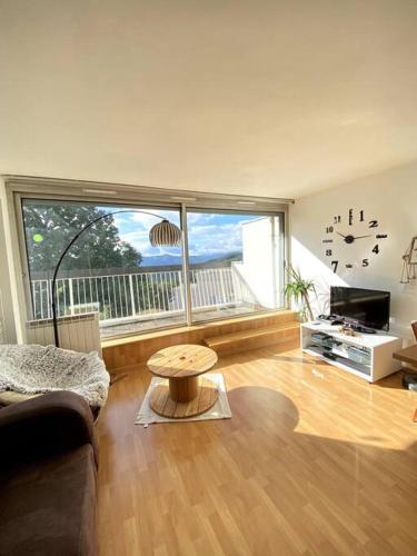 un salon avec un canapé et une grande fenêtre dans l'établissement Le Havre des Sommets - Free parking - Terrace, à Trois-Épis