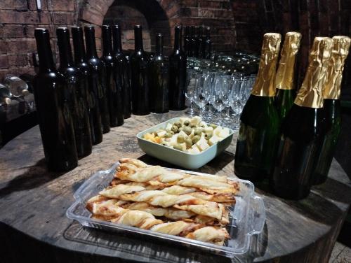 un tavolo con vassoio di prodotti alimentari e bottiglie di vino di Vitaj Kamaráde - Ubytování U Jožky a Mutěnice