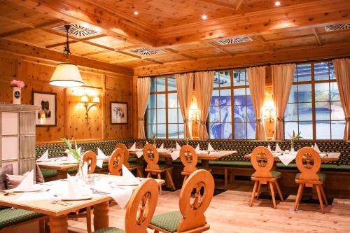 un comedor con mesas, sillas y ventanas en Resort Hotel Bispingen Superior en Bispingen