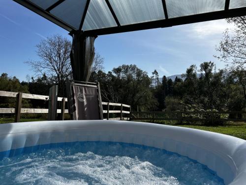 a hot tub in a yard with an umbrella at Glamping PEC - All Inclusive light in Selnica ob Dravi