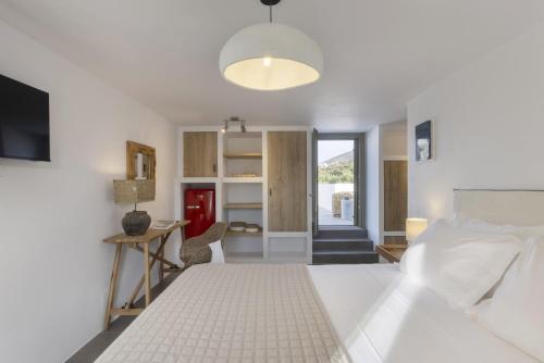 a bedroom with a large white bed and a desk at K1 - Villa Astra in Andiparos