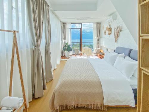 um quarto com uma cama grande e vista para o oceano em Dali Erhai Forest River View Hostel em Dali