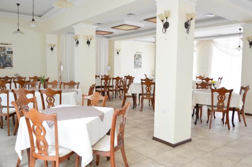 een eetkamer met witte tafels en stoelen bij Park hotel Bellevue in Goudstrand