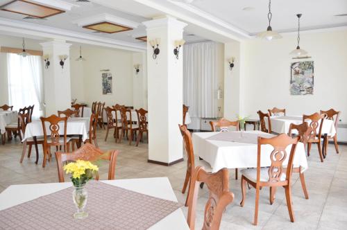 een eetkamer met witte tafels en houten stoelen bij Park hotel Bellevue in Goudstrand