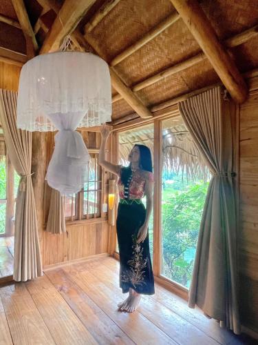 a woman standing in a room with a wedding dress at Pu Luong Ecostay in Lũng Tiềm