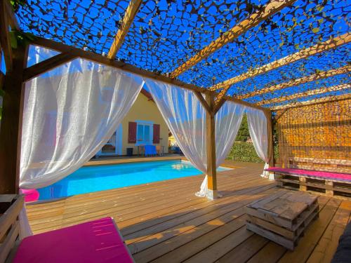 une pergola au-dessus d'une piscine dans une maison dans l'établissement Love-Room Chic&Glam', à Saint-Vincent-de-Paul
