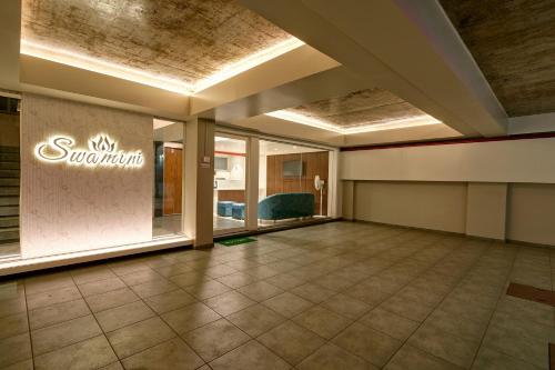 a lobby of a hotel with a sign on the wall at Hotel Swamini Kolhapur in Kolhapur