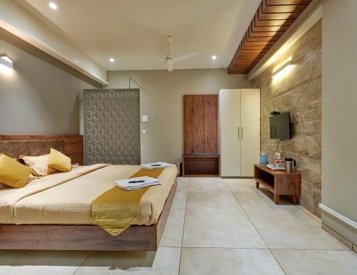 a bedroom with a large bed and a television at Hotel Swamini Kolhapur in Kolhapur