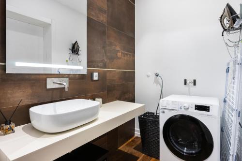 ein Badezimmer mit einer Waschmaschine und einem Waschbecken in der Unterkunft San Marco White Appartamento Luxury con Garage su richiesta in Florenz