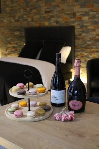 - une table avec deux bouteilles de vin et une assiette de beignets dans l'établissement L'Alchimie, à Salasc