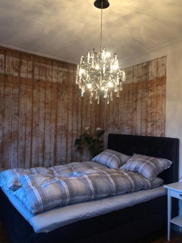 a bedroom with a large bed with a chandelier at Villa Henrikke Myhre in Osøyro