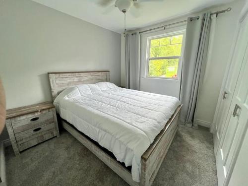 Un dormitorio con una cama grande y una ventana en Chalet sur le bord de l'eau, en Mallorytown