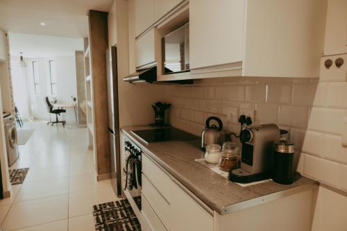 a kitchen with a sink and a counter top at Luxury Apartment near Grove Mall & Hospital Airbnb VELDT Suite in Windhoek