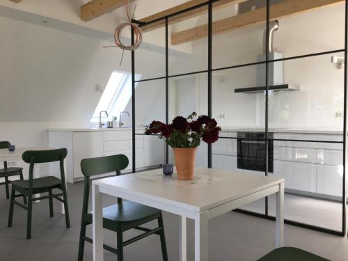 a kitchen with a white table and green chairs at Nije Haven Bed & Breakfast in Wrixum