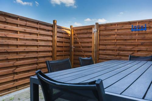 a wooden table and chairs in front of a fence at Zentrumnahe Wohnung in Ingelheim in Ingelheim am Rhein