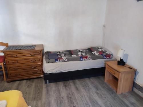 a bedroom with a bed and a wooden dresser at Chambre déplacement professionnel in Zilling