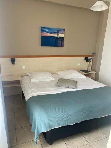 a bedroom with a large bed with two pillows at Hôtel de la jetée in Centuri