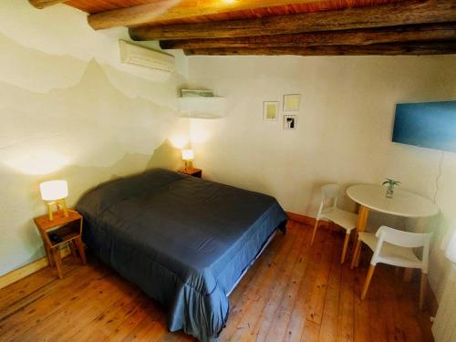 1 dormitorio con 1 cama y 1 mesa con sillas en Aires de Coria con parking en Chacras de Coria
