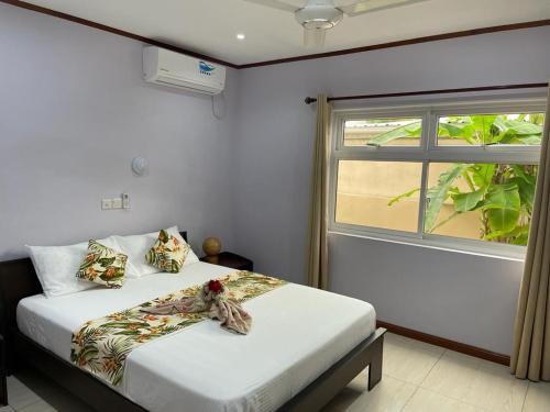 a bedroom with two beds and a window at Mokara Holiday Apartment in Mahe