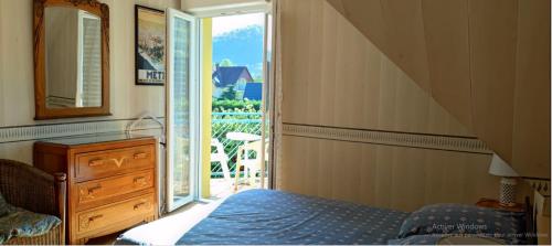 sypialnia z łóżkiem i drzwiami prowadzącymi na balkon w obiekcie Alsace nature et découvertes w mieście Gunsbach