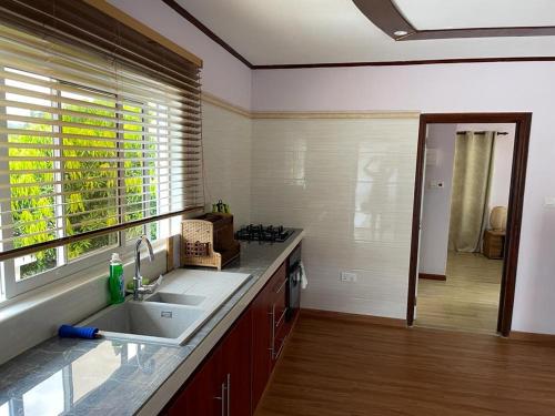 a kitchen with a sink and a window at Mokara Holiday Apartment in Mahe