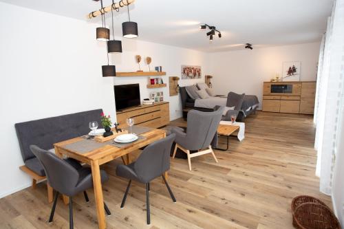 een eetkamer en een woonkamer met een tafel en stoelen bij Ferienwohnung Albblick in Burladingen